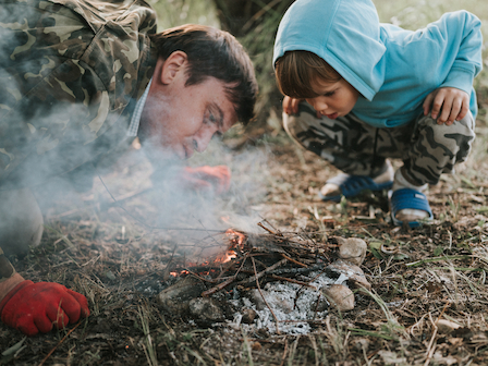 A child learns fire-building techniques at Preserve Resort & Spa, an engaging survival skills activity.