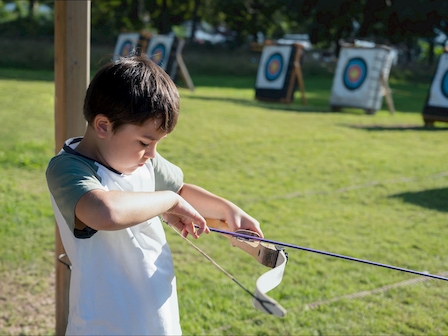 Young archer practices at Preserve Resort & Spa's Children's Club, promoting focus and fun in a safe outdoor setting.